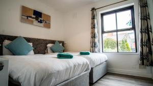 two beds in a room with a window at Liberty Townhouses in Dublin