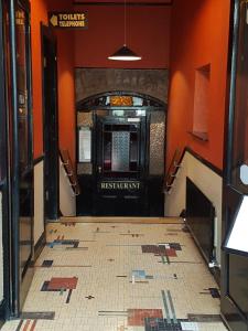 a hallway with orange walls and a black door at Royal Spa Hotel in Lisdoonvarna