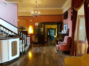 a living room with a staircase and a fireplace at Royal Spa Hotel in Lisdoonvarna