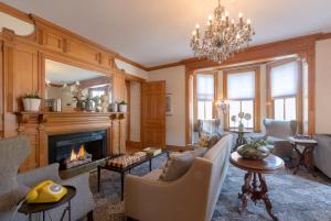 a living room with a fireplace and a chandelier at The Hotel Portsmouth - Downtown in Portsmouth