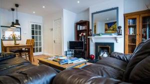 a living room with a leather couch and a table at Liberty Townhouses in Dublin