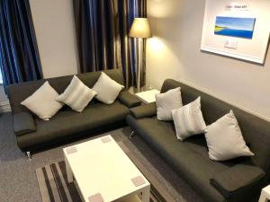 a living room with a couch and pillows at Stay Lytham Serviced Apartments in Lytham St Annes