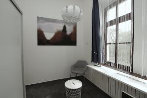 Habitación blanca con silla y ventana en Koleje Zamecek en Lednice
