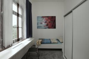 a bedroom with a bed and a desk and windows at Koleje Zamecek in Lednice