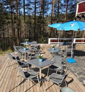 a group of tables and chairs with an umbrella at Hotelli Kägöne in Parikkala