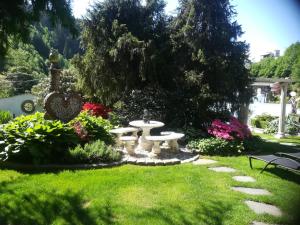 einen Garten mit einem Picknicktisch und Blumen in der Unterkunft Ferienwohnungen Garten Eden in Trebesing