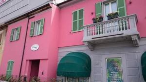 a pink building with a balcony and a window at Bed & Breakfast Oltrepo in Casteggio