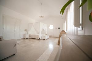 a large white room with a bed and a table at Antica Masseria Ficazzana - Tenuta in Marina di Pescoluse