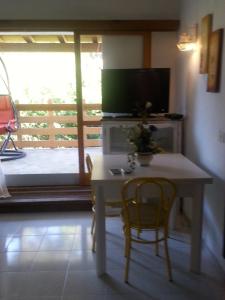 a living room with a table and a television on a balcony at Casa vacanza Gigi e Antonella in Porto Rotondo