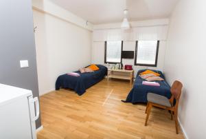 two beds in a room with a table and a chair at Afrodite Rooms in Naantali