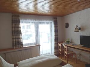 1 dormitorio con escritorio, 1 cama y ventana en Hochschwarzwald-Hof, en Schluchsee