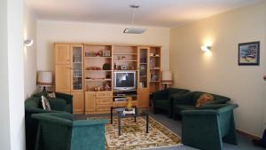 a living room with two green couches and a television at Kolping House in Lamego