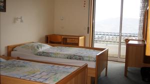 a bedroom with two beds and a large window at Kolping House in Lamego +31 photos