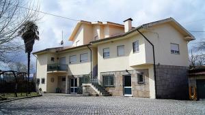 a large white house with a driveway in front of it at Kolping House in Lamego