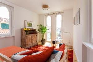 uma sala de estar com um sofá e duas janelas em Lisbon Sea Side Chalet em Paço de Arcos