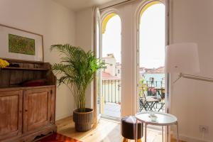 ein Wohnzimmer mit einem Tisch und einer Pflanze in der Unterkunft Lisbon Sea Side Chalet in Paço de Arcos