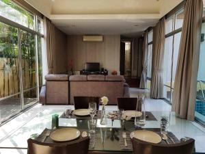 een woonkamer met een tafel, stoelen en een bank bij AnB pool villa (Red) with 2BR close to Jomtien beach in Na Jomtien