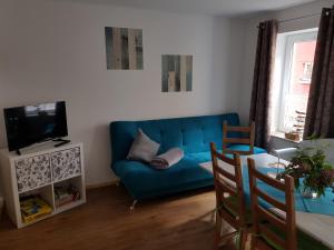 a living room with a blue couch and a tv at "kleine Boddenburg" in Barth