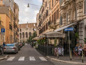 una strada cittadina con auto parcheggiate sulla strada di Colosseo 85 a Roma