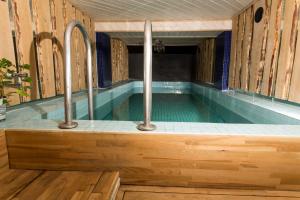 a lap pool in a wooden house with a swimming pool at Afrodite Rooms in Naantali