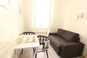 uma pequena sala de estar com uma mesa e um sofá em Penna Flats em Roma