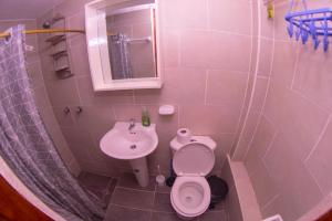 a pink bathroom with a toilet and a sink at Samay Apart in Baños