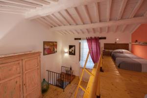 Un dormitorio con una cama y una escalera en una habitación en Fienile Vignanova, en Gerfalco