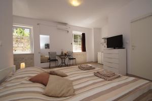 Un dormitorio con una cama grande con almohadas. en White House Apartments, en Korčula