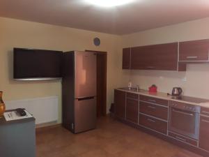 eine Küche mit braunen Schränken und einem Kühlschrank aus Edelstahl in der Unterkunft Ubytovani Salajkovi in Moravská Nová Ves