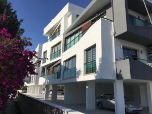 a white building with a car parked in front of it at Royal Residence Nicosia in North Nicosia