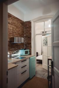 a kitchen with a microwave and a brick wall at Boutique Apartments Possonium in Bratislava