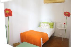 a bedroom with a bed with two red flowers on the wall at Hope House in Póvoa de Varzim