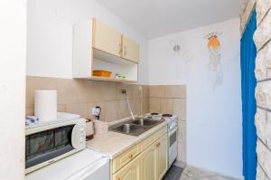 a small kitchen with a sink and a stove at Rooms Nikola in Dubrovnik