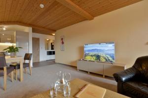 ein Wohnzimmer mit einem Flachbild-TV an der Wand in der Unterkunft Gästehaus Rottenspacher in Kössen