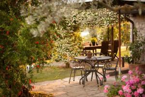 een tafel en stoelen in een tuin met bloemen bij Tenuta Di Canonica in Todi