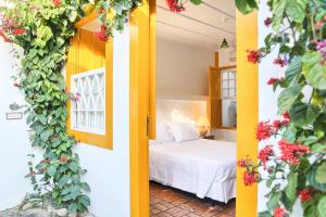 um quarto com uma cama num quarto com flores em Pousada do Ouro em Paraty