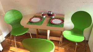 ブダペストにあるBelle apartmentのテーブル(緑の椅子付)、食器、ドリンク