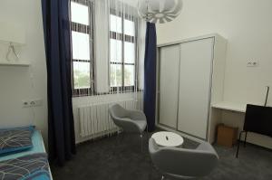 a room with two chairs and a desk and windows at Koleje Zamecek in Lednice