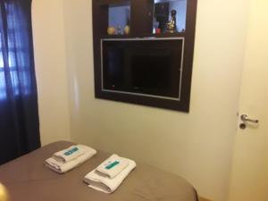 Habitación con mesa, TV y 2 toallas. en Departamento Neuquen en Neuquén