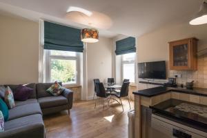 uma sala de estar com um sofá e uma mesa em Kingsway Apartment em Bishop Auckland