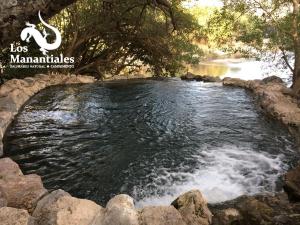 basen z wodą w rzece z kamieniami w obiekcie Balneario Natural Los Manantiales w mieście Coaxitlan