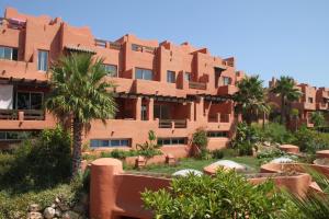 een groot bruin gebouw met palmbomen ervoor bij Seaview Villa Vistagibraltar in Manilva