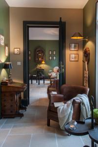 een woonkamer met banken en stoelen en een spiegel bij Les Buis de Boscherville Gite in Hénouville