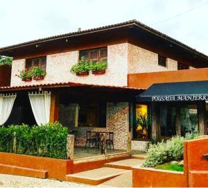 a building with potted plants on the side of it at Pousada Manjericão in Guaramiranga
