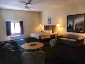 a hotel room with a bed and a living room at Super 8 by Wyndham Bridgeview of Mackinaw City in Mackinaw City