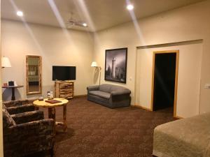 ein Wohnzimmer mit einem Sofa und einem TV in der Unterkunft Super 8 by Wyndham Bridgeview of Mackinaw City in Mackinaw City