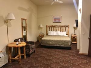 ein Schlafzimmer mit einem Bett, einem Stuhl und einem Tisch in der Unterkunft Super 8 by Wyndham Bridgeview of Mackinaw City in Mackinaw City
