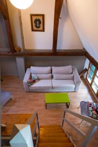 ein Wohnzimmer mit einem weißen Sofa und einem grünen Tisch in der Unterkunft Gîte - Logement rénové dans ferme alsacienne in Pfettisheim