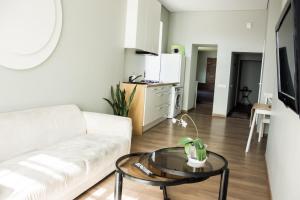 a living room with a white couch and a table at Owl Apartments in Kaunas