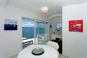 a living room with a table and a view of the ocean at Blue Bay Residence in Hvar